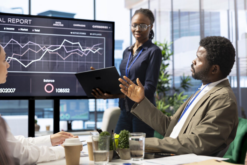 Diverse management team evaluates budget reports on interactive board